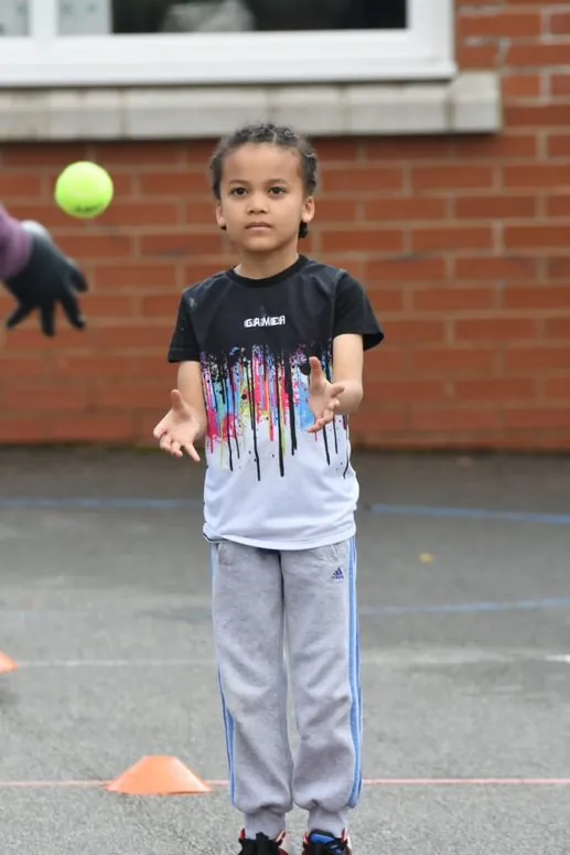 Young child practicing his catching skills at a YCF outside session