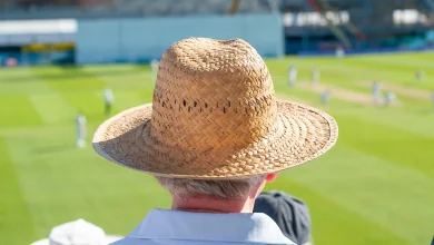 Spectator in a straw hat watches from North East Upper at Headingley.