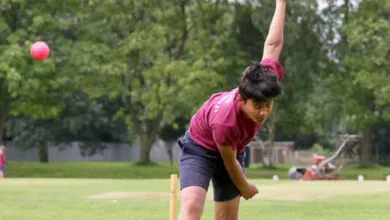 Young male bowler practicing with a pink ball before a game
