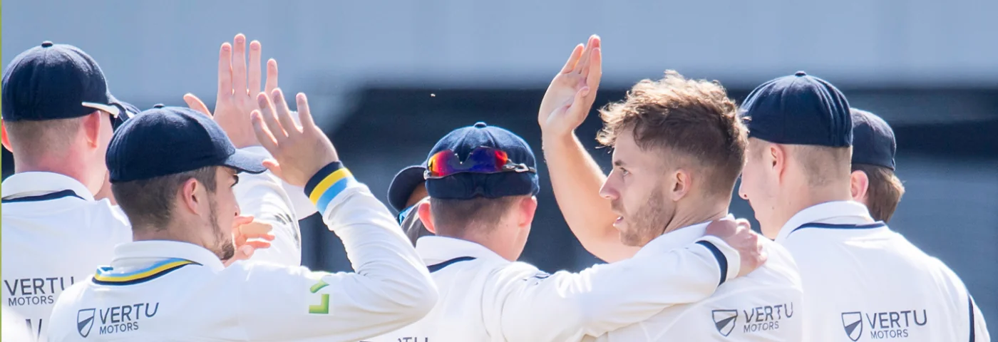 Ben Coad celebrating wicket with Jordan Thompson and other YCCC players.
